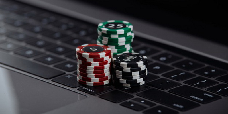 Laptop and chips on it - Poker in Lithuania for real money online